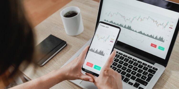 Forex trader using crypto exchange mobile phone app for investment and stock market analysis at hedge fund office - Focus on screen