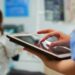 Close up of nurse holding and typing on tablet standing in stomatologic clinic, while doctor is working with patient in background. Using monitor with chroma key izolated pc key mockup pc display