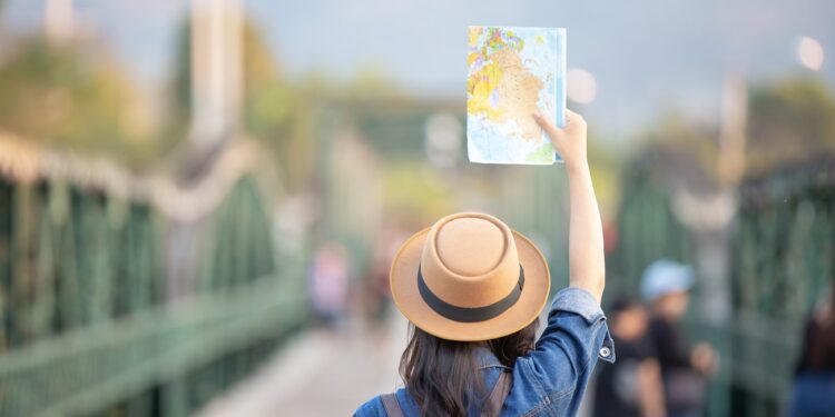 Female tourists on hand have a happy travel map.