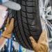 Seasonal Car Tires Change. Replacing Summer Tread to Winter Tread. Automotive Theme. Caucasian Car Service Worker Performing Scheduled Replacement.