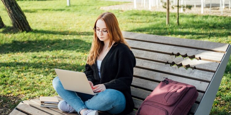 Artificial Intelligence AI in education industry. Applications of Artificial Intelligence and chatbots in Education. Student girl with laptop using chatbot for studying process.
