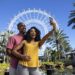 Couple posing for a selfie in front of The Wheel at ICON Park
