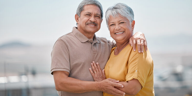 Couple, happy and outdoor portrait of senior love on retirement vacation in a city bonding and hugging with smile and care. Happiness, support and elderly man and woman being romantic in Puerto Rico