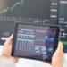 Tablet in hands, graphs and stock market with fintech and trading, investment and financial stats o.