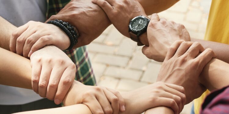 Close-up image of people holding each others wrists
