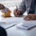 Discussion with a real estate agent, House model with agent and customer discussing for the contract to buy, get insurance or loan real estate or property.