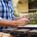 Handsome man relaxing in his garden using laptop to shop on a sunny day