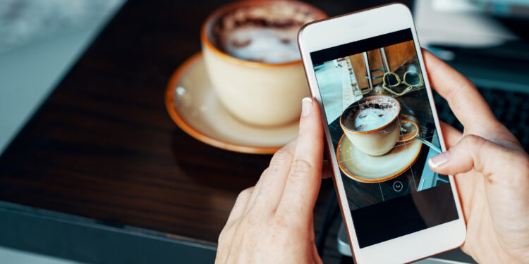Female blogger taking photo of her coffee to make a post
