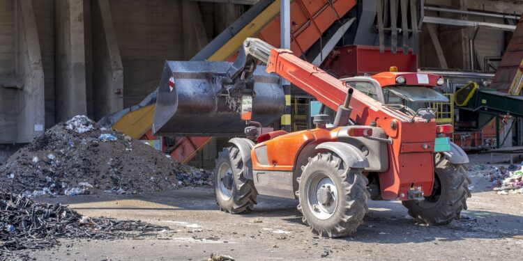 A loader transporting soil and waste materials at a waste treatment plant