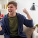 excited young blonde handsome man sits on armchair keeping fist and looking at phone inside design living room SSUCv3H4sIAAAAAAAACpyRz27DIAzG75P2DhHnRiIk6p+9SrWDY1iDSqECsmmq+u4zECrOu+Gf7c/+zOP9revYDEEj++geKaJYG7OG6CFqZwnz3ca9slL5liipo/MaTAtniLhYuCmCdjUm4WdOshAhrkGFNGxDCFFdSKPAl0TZ6FziriZykjooxdiuYWGdM6uoiP+rszw+qxu4KIu/eeHGiFdGQTFyLqXs+hOVv7XWYJXaNa6+HYJJBWOjdPcatb00bS4u+cq1Dd1qo08rvDZnxrk7zCad+Is0VeULhEDlsvJmENKfulszx7qYDWyqTNJPpHAYxXSahOCcH04DHw77raD83qJJJ69ThSjGq5atdZ02YHwa4XQUop+PQvWTlKqfBQ69ADwgiiMXsKfDP/8AAAD//wMALedqr4cCAAA=