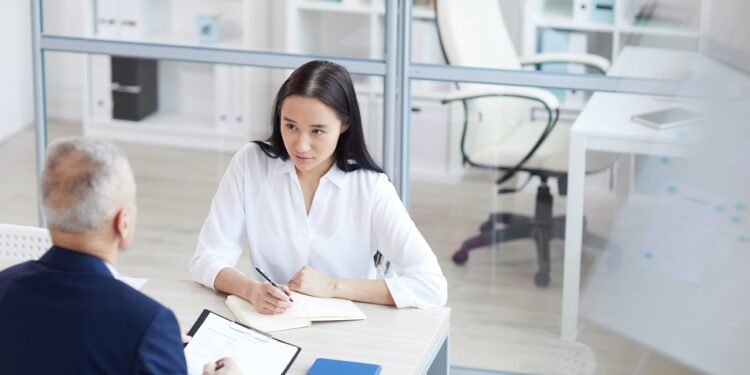 High angle portrait of young woman answering questions during job interview in office, copy space