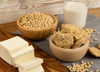 Soy food collection with dry soy meat, soybeans, soy milk and tofu on rustic background. Soy products mix
