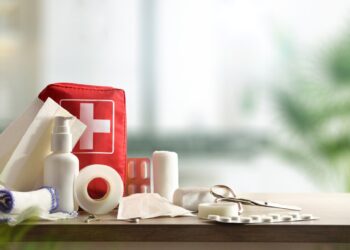 Emergency home kit on wooden table and warm room background. Horizontal composition. Front view.