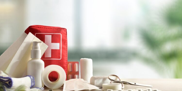 Emergency home kit on wooden table and warm room background. Horizontal composition. Front view.