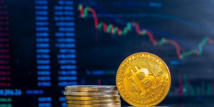 Close-up of golden Bitcoins on a dark reflective surface and the histogram of decreasing crypto in the background