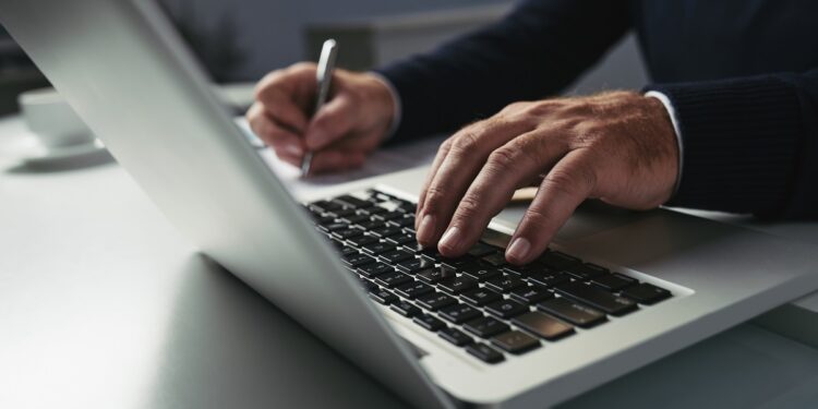 Close-up image of businessman working on laptop at his table