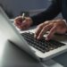 Close-up image of businessman working on laptop at his table