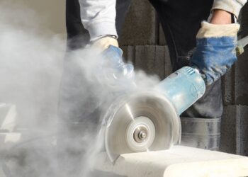 Worker cutting stone with grinder.