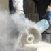 Worker cutting stone with grinder.