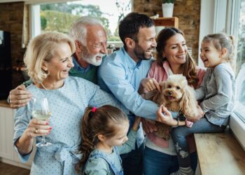 Cheerful multi-generation family with a dog having fun while spending time together at home.