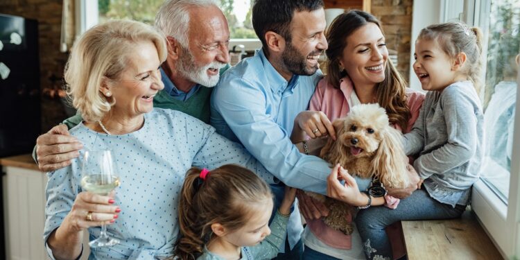 Cheerful multi-generation family with a dog having fun while spending time together at home.