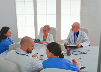 Healthcare workers having meeting in hospital conference room about symptoms of patients analysing x-ray. Clinic expert therapist talking with colleagues about disease, medicine professional
