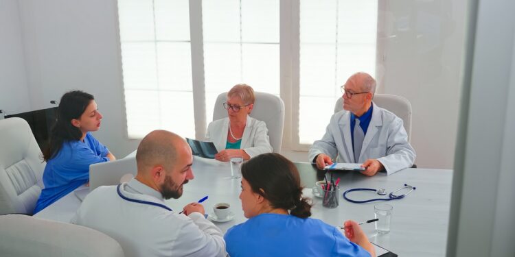 Healthcare workers having meeting in hospital conference room about symptoms of patients analysing x-ray. Clinic expert therapist talking with colleagues about disease, medicine professional
