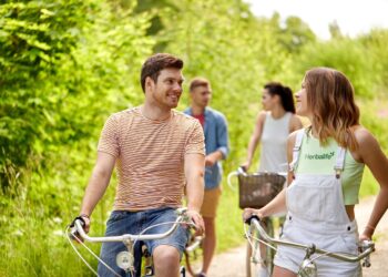 Four people with an active lifestyle, cycling on a path while wearing our brand's apparel