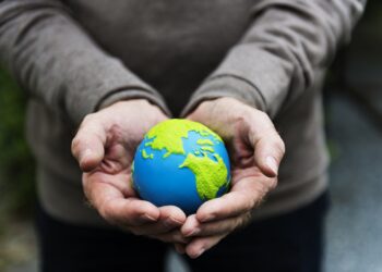 Hands holding a clay globe planet Earth