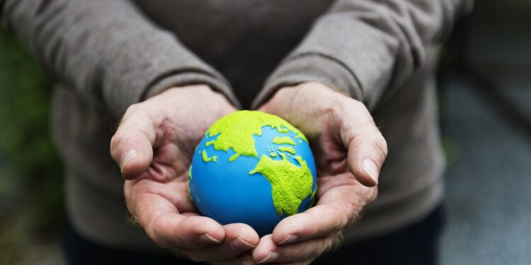 Hands holding a clay globe planet Earth