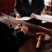 Close-up of accusation and protection sides with juridical documents standing in front of female judge during discussion of case points SSUCv3H4sIAAAAAAAACpxUyW7bMBC9F+g/GDyHAHeR/ZWih+EWC5FFQ6JSBEH+vZQs2pQPOfRGvnmzch4/f/44nZCFuXfo1+lzvZV7PwzLnCfIfRoLTF52fAqjD1OLvE9ckRaAvr0F3+c09TC0oIXsziNcQgHHZRhW+GszojlDXuYwN7X4KcBlzv1G5zXGNY1eFoBWYD4vOYdpzsm9tUQY4PLREinjU2wZPlzT3OfrOeU0H3KsiF/GQ2LwyYZ7lqZ0Bzm8ll4PxdfB/r7dT9WwGYtHMSG0h761sdgNq9At+H953g5/7oW/htGtk/j8aqqewhDgNvC9RiSIVaDA4tBRhoUhFlsrIxYMCPGOqsB9zYxA2CAE15hpa7HwymMQEbCUoKknzsVO3cneMmmDotgzKgpZOgzRlUSMRm5dLHxyJwcpA2UgMZHBlzICweCFxSR6sMRRzr2+k6UIVomocecUx8KSgC2QDhvJNLWWRxrMNpnbONDb37Irl+2l9kHA4vvUvNx7cjBs69BMC/orTHDwu06968fXBkn5vGmkRnJpGfP00T4YGlK6gh3WzYolTaj4Gea50H3F2/0qikyXJs+Y8vZue1TkywKu1zIZwRmXTGmphWFin+kurnNf4mzl1AKX65DAhzXpfcmOsqPKaCIlJ1VFrQKrTT1sT2KsFNa433VZbeJhqxLdbabTjV+rv5XQKcKMudmrWlYxXPpSwrGnQ1zFCG9yPv8CO4fy7uWbmRSC7L7vWzElmtG0n8pm76jh5Nv+KBdk7+/wVRZO79vfpvaHYByh1DkMM+OUECLYQyrPjSKlmaFlXcSD0vaJmBGio10T4qlNxHinNeElyJ3StokidT6aYHBwukg5cIu1pwpH7oRl1nRcPjwPA0CqI7JTWnSbevfW+/VZEV9fnnCFwdjym4jykZhIivppFCwEAYaH4vX1DwAA//8DAL92mYjjBgAA