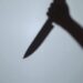 The shadow of a murderer kills his victim with a knife at night.