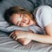 Woman sleeping. Beautiful young smiling woman sleeping in bed