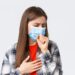 Coronavirus outbreak, leisure on quarantine, social distancing and emotions concept. Close-up of sick young woman in medical mask staying at home during covid-19, cough with closed eyes.