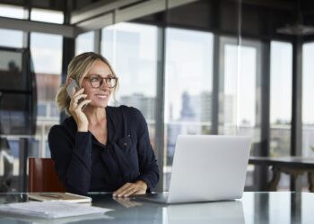 Businesswoman sitting in office, talking on the phone