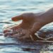 Hand touching water.