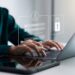 Securing cybersecurity, A Businesswoman protecting personal data on laptops and virtual interfaces, Preventing Online Theft, Cybersecurity concepts.