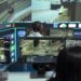African american employee following delivery trucks around the city, sending gps coordinates for cargo location by using satellite map. Monitoring couriers in traffic on CCTV footage.