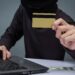 thieves hold credit cards using a laptop computer for password h