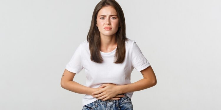 woman having stomach ache, bending and holding hands on belly, discomfort from menstrual cramps. girl feeling nauseous
