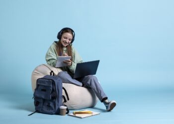 student wearing headphones and holding notebook, practicing before exam