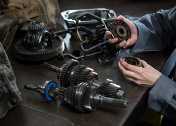 female mechanic holding spare parts of car