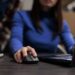 woman managing parcel delivery on laptop in warehouse