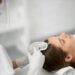 beautician in protective mask doing procedure for hair.