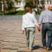 senior adults walking in a park holding hands
