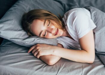 beautiful young smiling woman sleeping in bed