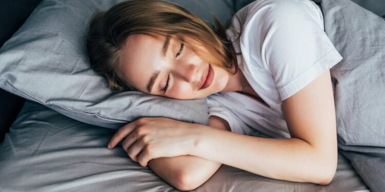beautiful young smiling woman sleeping in bed