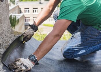 worker performs overhaul of the roof of a residential building
