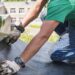 worker performs overhaul of the roof of a residential building