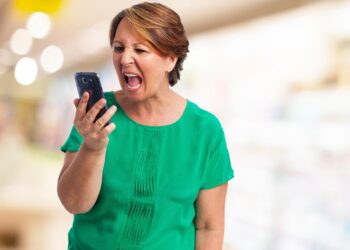 portrait of angry mature woman talking on telephone